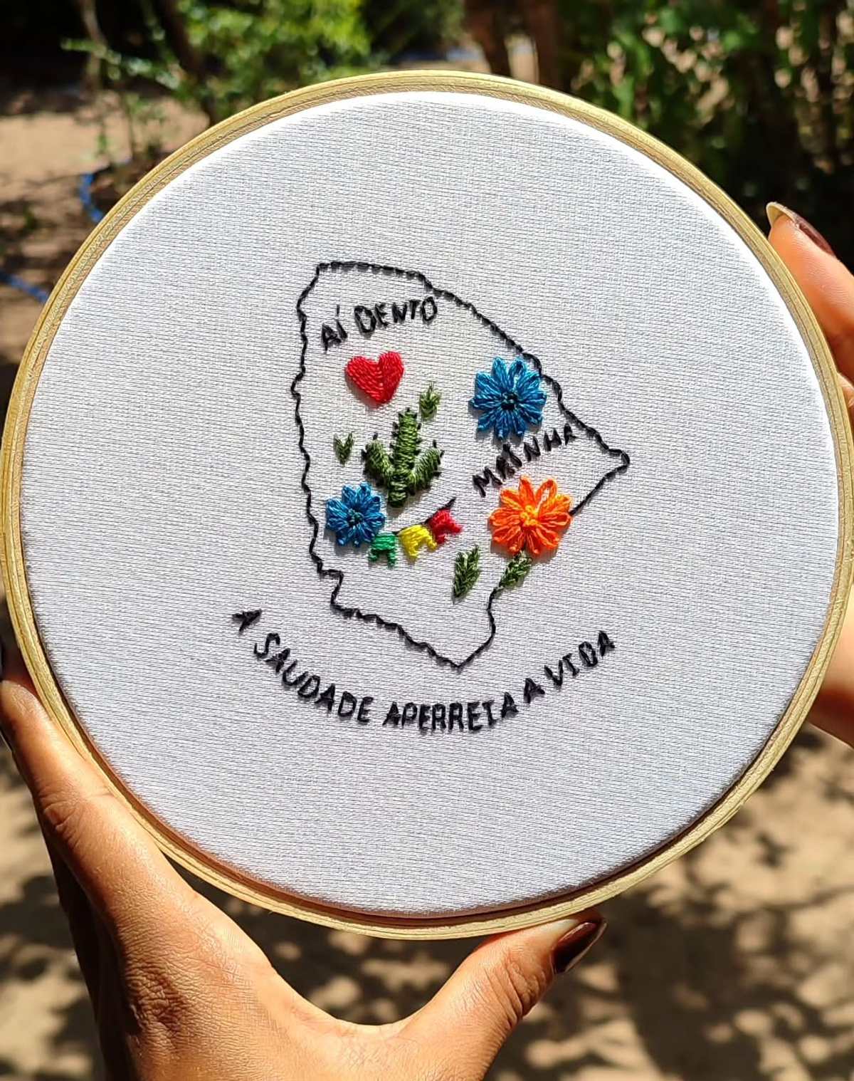 Bastidor com o mapa do Ceará cheio de flores e cactos coloridos