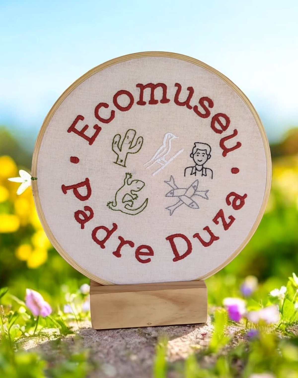 Bastidor de 30cm do Ecomuseu Padre Duza com letras vermelhas e desenhos